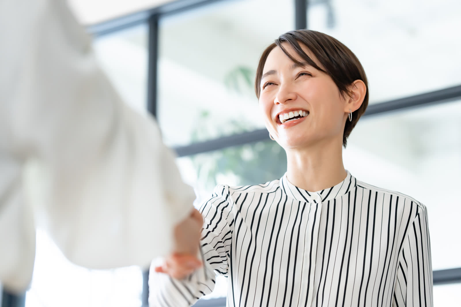 オフィスで笑顔で握手する人